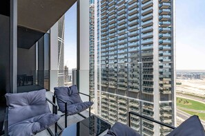 Ein Balkon mit moderner Einrichtung und Blick auf hohe Gebäude.