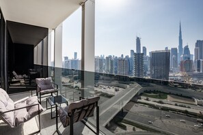 A balcony with a city view, modern furniture, and a clear sky. - Chic City Studio in Upside w/ Burj View (Dubai)