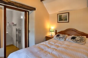 Une chambre à coucher avec un lit, une table de chevet, une lampe et un tableau au mur.