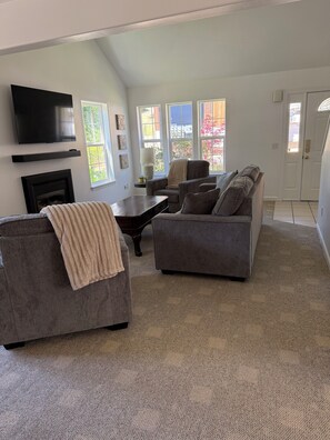 A living room with a fireplace, a flat-screen TV, and a sofa. - 3-bedroom townhome in lovely White Salmon with AC (White Salmon)