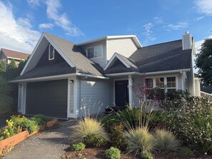 Ein Wohnhaus mit Garage, einer Veranda und einem gepflegten Garten.