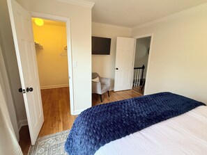 Ein Schlafzimmer mit einem Bett, einem Sessel und einer Tür zu einem Badezimmer.
