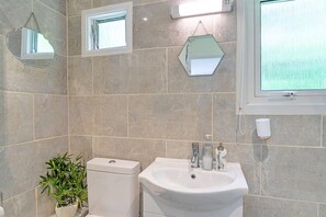 A bathroom with a toilet, sink, and a potted plant. - Camelford Base Near Beaches (Camelford)