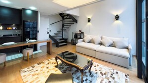 Ein zeitgemäßer Wohnraum mit Treppe, Essbereich und Sofa.