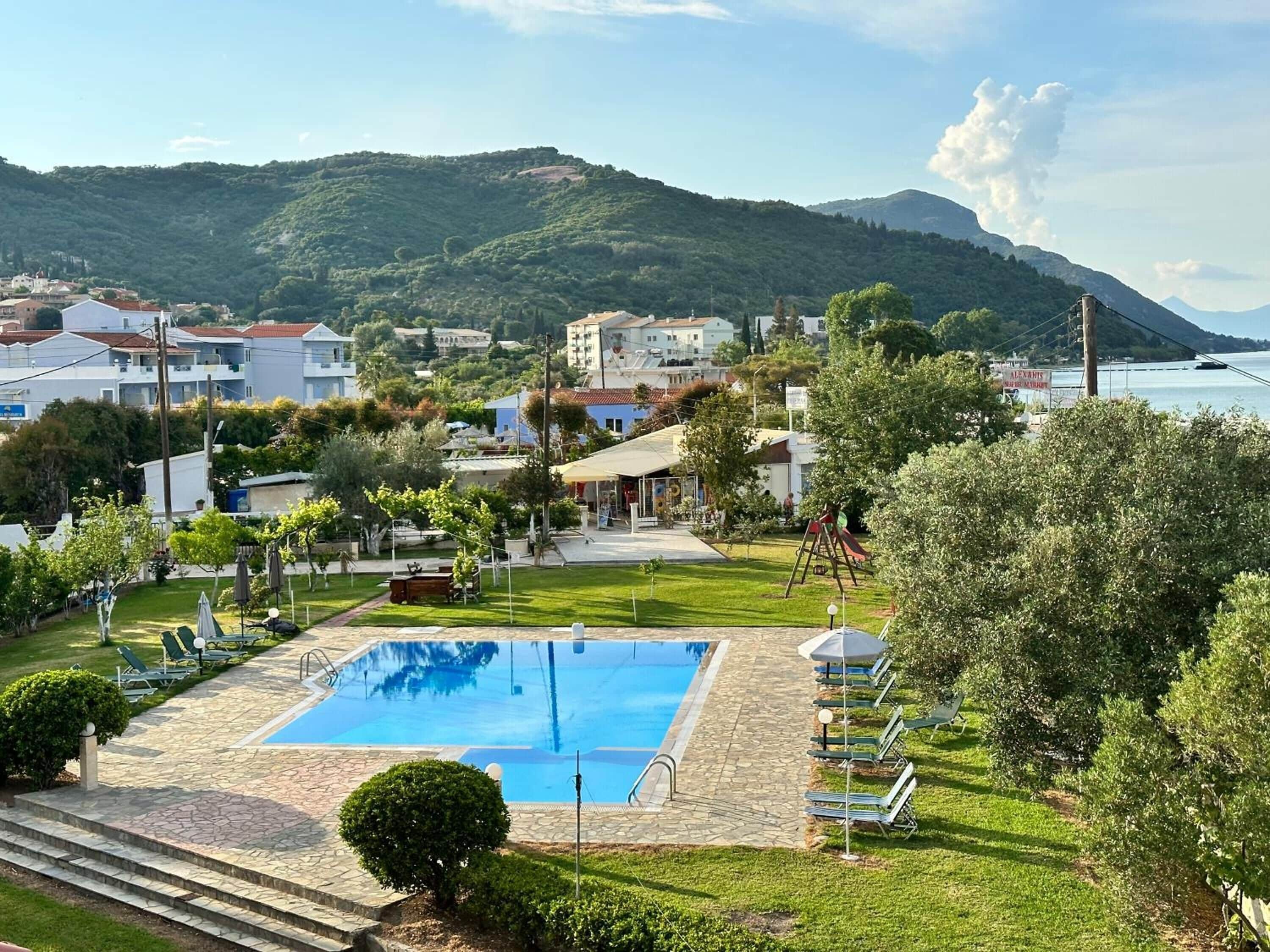 A swimming pool with a view of a town and mountains in the background.