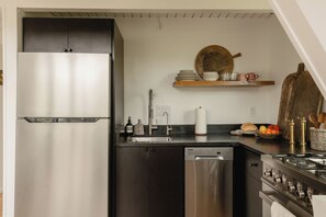 A compact kitchen with a stainless steel refrigerator, dishwasher, and stove. - Cozy A-Frame Retreat w/Fireplace & View (Crestline)