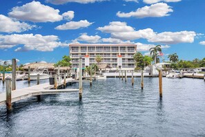 Um hotel à beira-mar com várias varandas, um cais e uma marina com barcos.