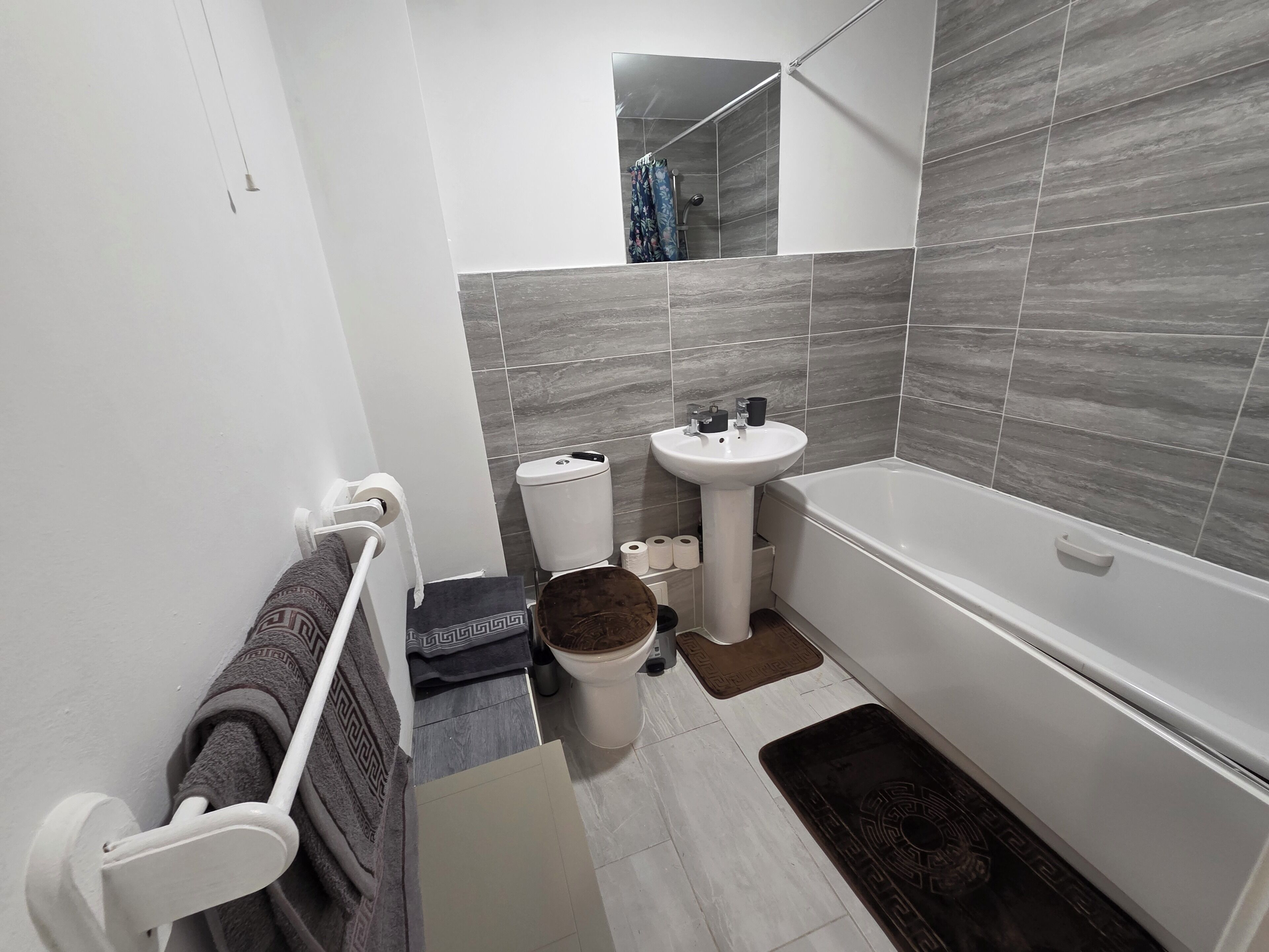 A bathroom with a toilet, sink, and bathtub.