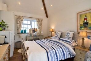 Une chambre à coucher avec un lit, des tables de chevet, une commode, un miroir et un tableau accroché au mur.