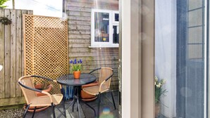 A patio area with a round table, four wicker chairs, and a potted plant. - Modern Studio Near Port Isaac (Bodmin)