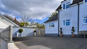 A residential property with a paved driveway, a wooden fence, and potted plants. - Modern Studio Near Port Isaac (Bodmin)