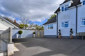 A residential property with a paved driveway, a wooden fence, and potted plants. - Modern Studio Near Port Isaac (Bodmin)