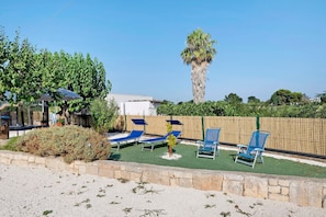 Ein Poolbereich mit Liegestühlen und einer Palme.