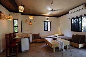 A modern living space with a kitchen area, seating arrangements, and pendant lighting. - Beautiful home in La Punta with a private pool, rooftop terrace, and AC. (Puerto Escondido)