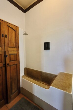 A bathroom with a wooden door, a shower, and a built-in shelf. - Beautiful home in La Punta with a private pool, rooftop terrace, and AC. (Puerto Escondido)