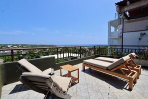 A balcony with two lounge chairs and a small table, overlooking a coastal view. - Beautiful home in La Punta with a private pool, rooftop terrace, and AC. (Puerto Escondido)