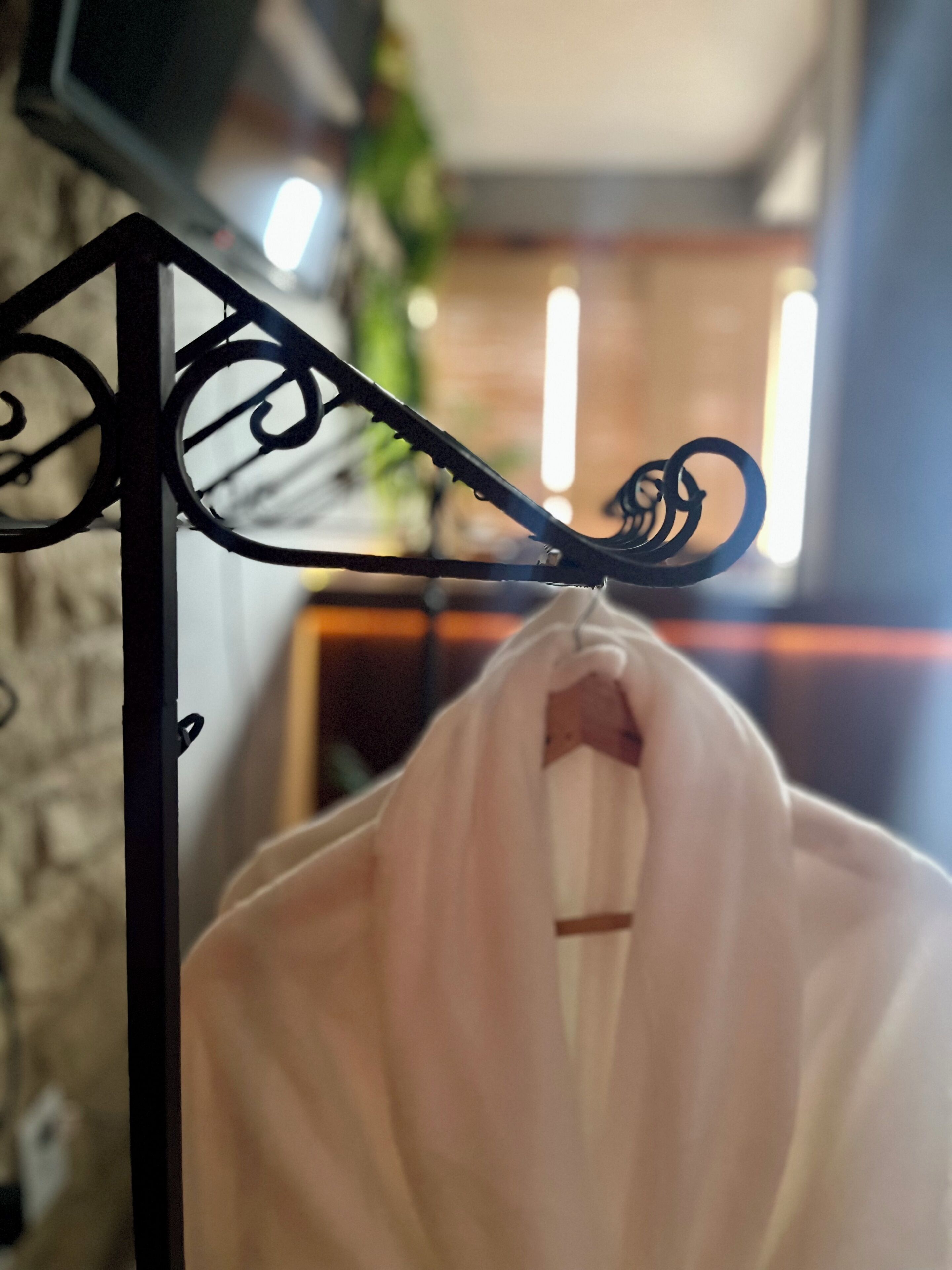 A metal rack with a white garment hanging on it.