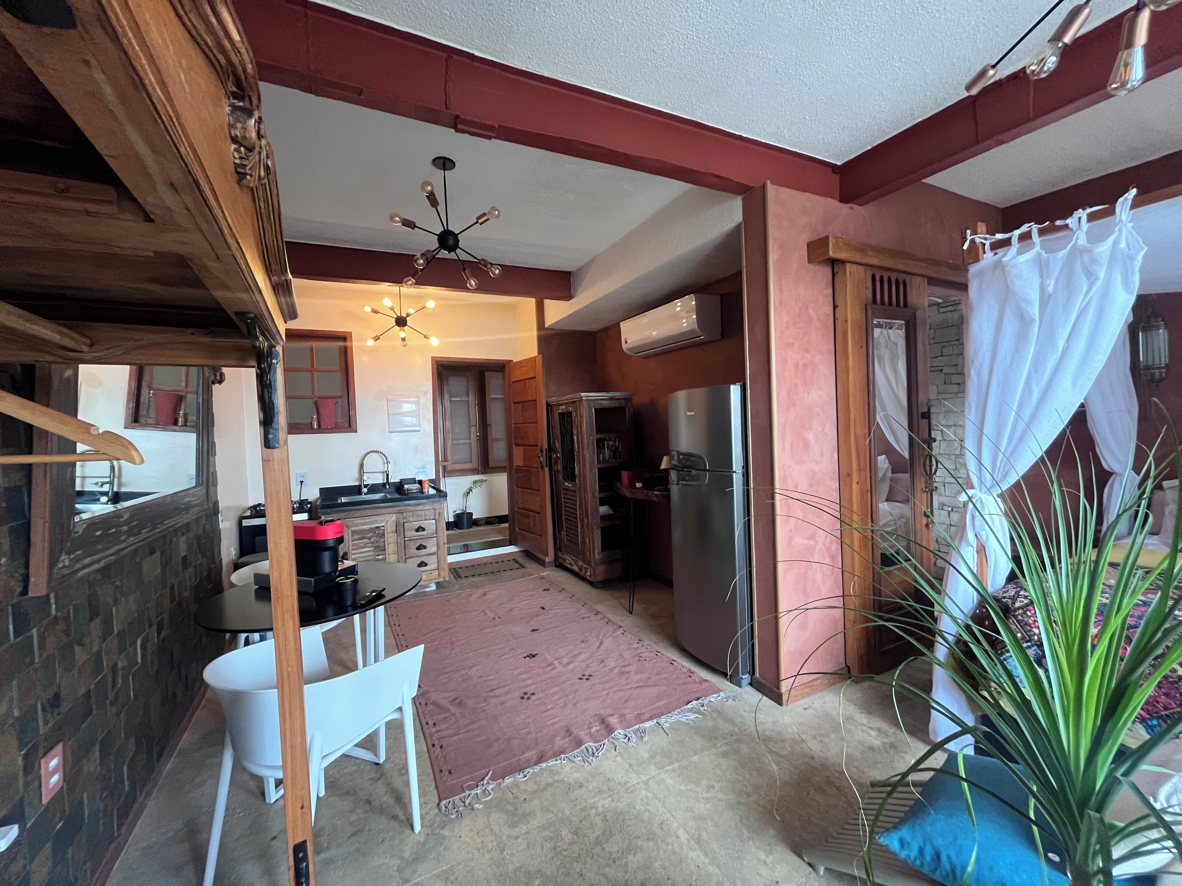 A compact kitchen with a dining area, a refrigerator, and a ceiling fan.