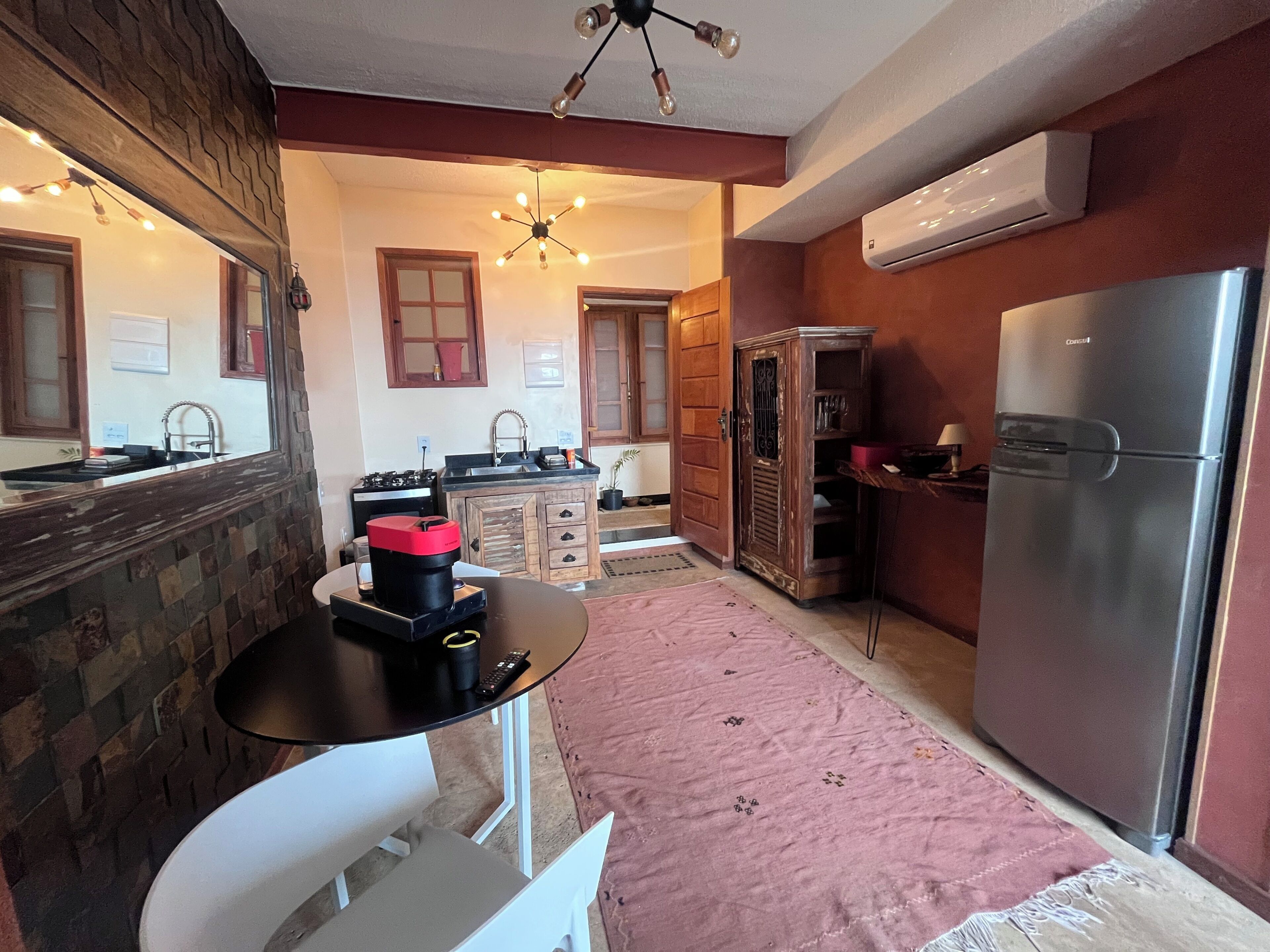 Una cocina compacta con refrigerador, lavamanos y estufa.