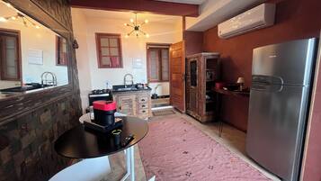 Una cocina compacta con refrigerador, lavamanos y estufa.