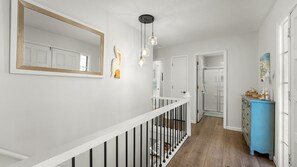 Ein Korridor mit weißer Geländer, einem blauen Schrank und einer Duschkabine aus Glas.