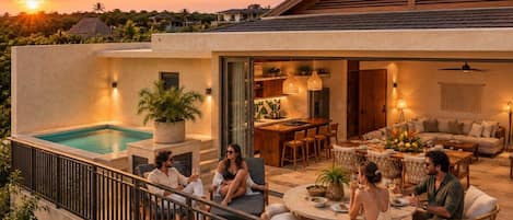 A modern outdoor living area with a pool, dining space, and a covered seating area.