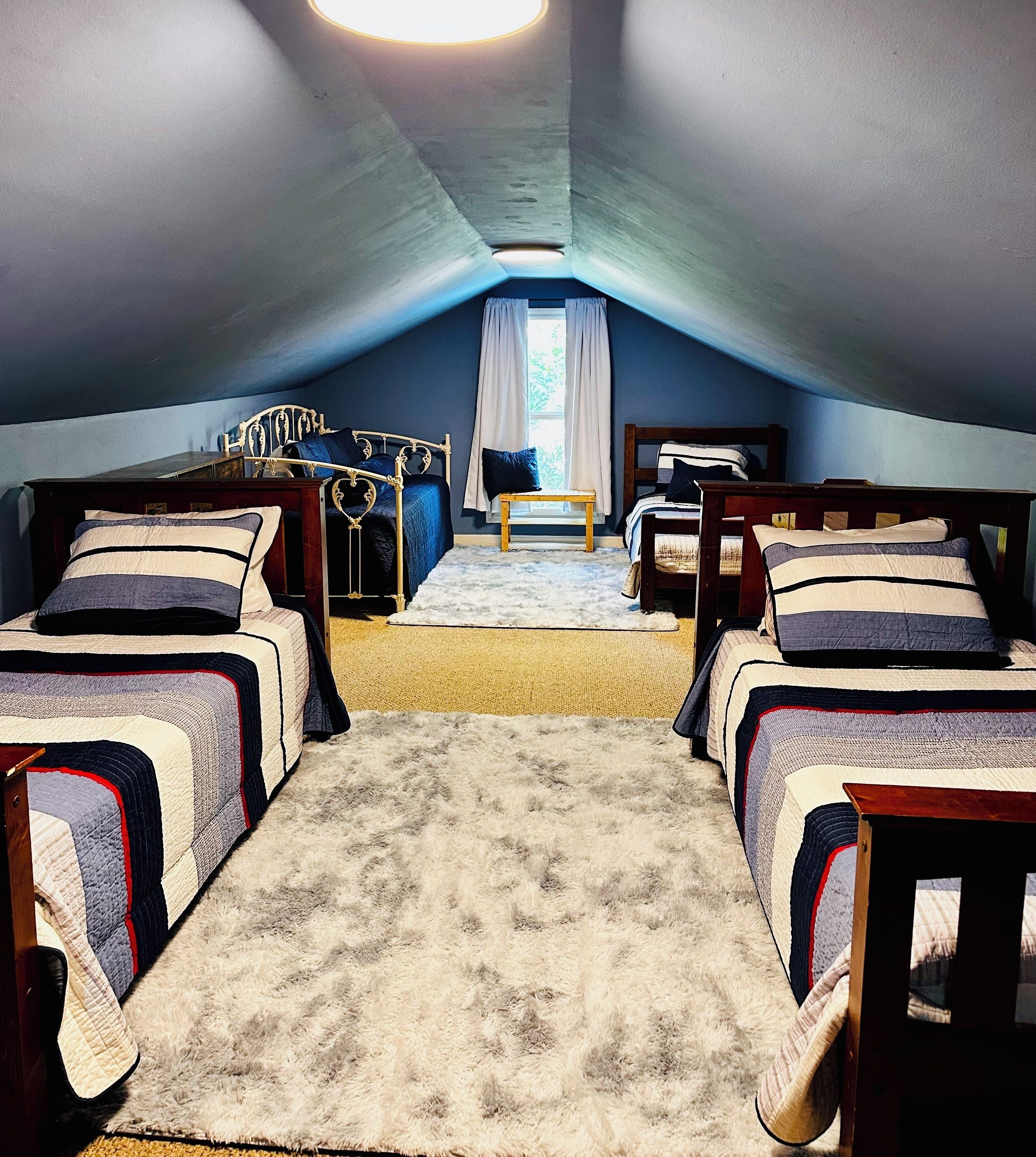 Een kamer met twee bedden, een tafeltje en een raam met gordijnen.