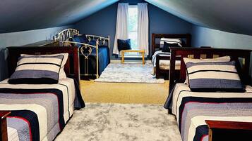 Een kamer met twee bedden, een tafeltje en een raam met gordijnen.
