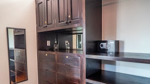 A kitchen with dark wooden cabinets, a stainless steel countertop, and a built-in microwave. - Lujo y confort capilla SM de Allende (San Miguel de Allende)