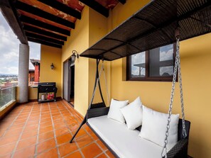 A balcony with a swing seat, a grill, and a view of the city. - Lujo y confort capilla SM de Allende (San Miguel de Allende)