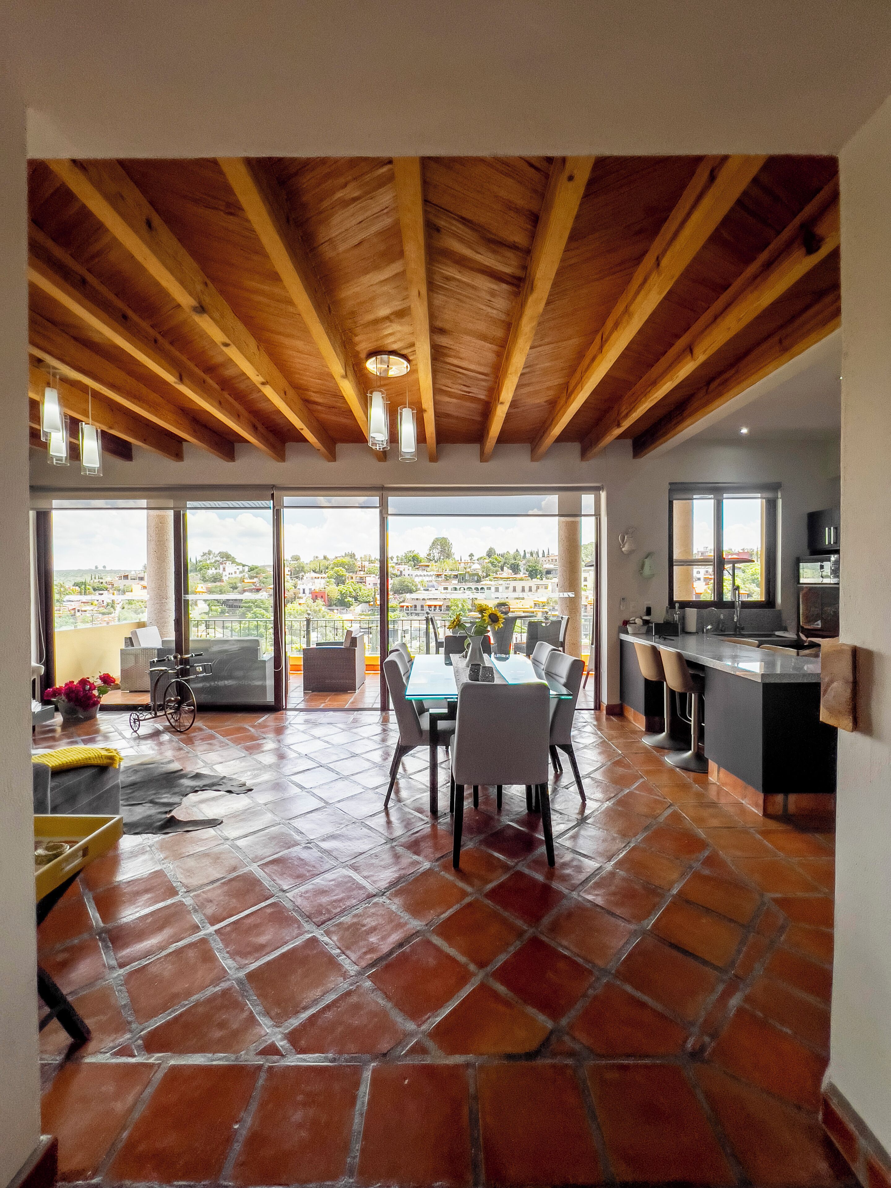 A spacious dining area with a high ceiling and large windows offering a view of the city.
