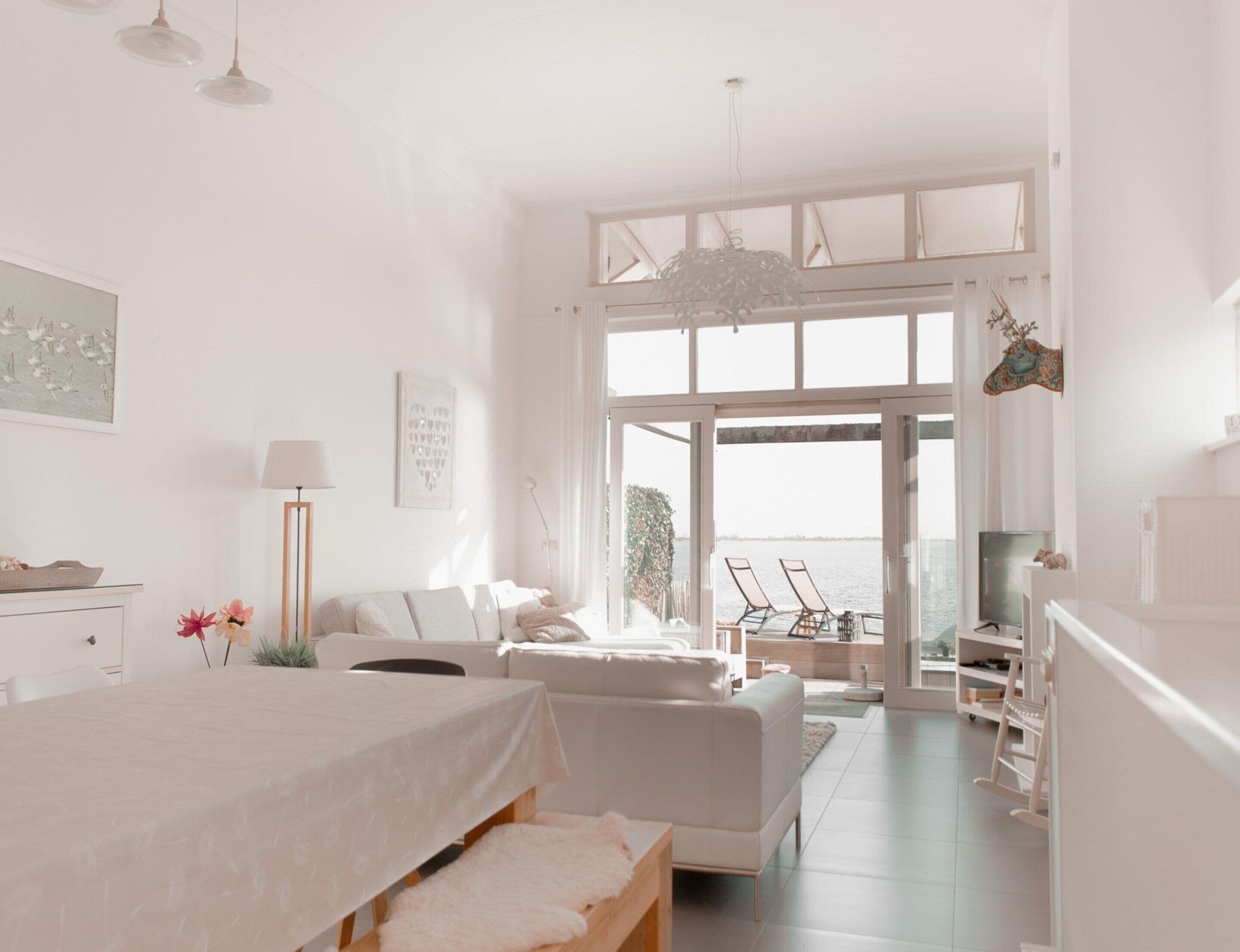 A spacious bedroom with a large bed, a sofa, and a balcony with a view.