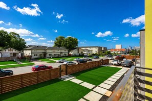 Zona residencial con varias casas de dos pisos, un estacionamiento y un césped.