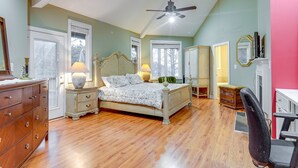 A bedroom with a bed, dresser, nightstands, lamp, and a ceiling fan.