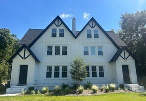 A two-story white building with a symmetrical facade, multiple windows, and a central chimney. - Moultrie Main Street Beauty 1125 (Moultrie)