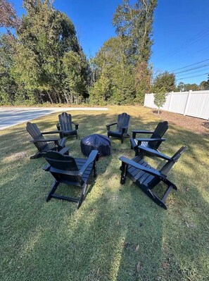 A lawn with four Adirondack chairs and a round table. - Moultrie Main Street Beauty 1125 (Moultrie)