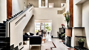 A spacious living area with a staircase, a fireplace, and a dining area. - Art Deco 6-Bedroom House in Condesa with a Rooftop (Ciudad de México)