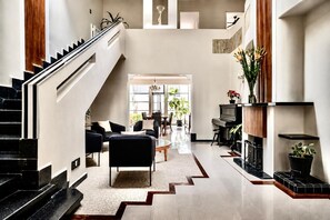 A spacious living area with a staircase, a fireplace, and a dining area. - Art Deco 6-Bedroom House in Condesa with a Rooftop (Ciudad de México)