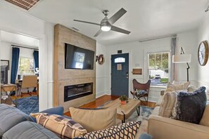 A living room with a fireplace, a ceiling fan, and a television. - 3 BD/ 2 BA/ Saint Augustine (311 FB) (Saint Augustine)