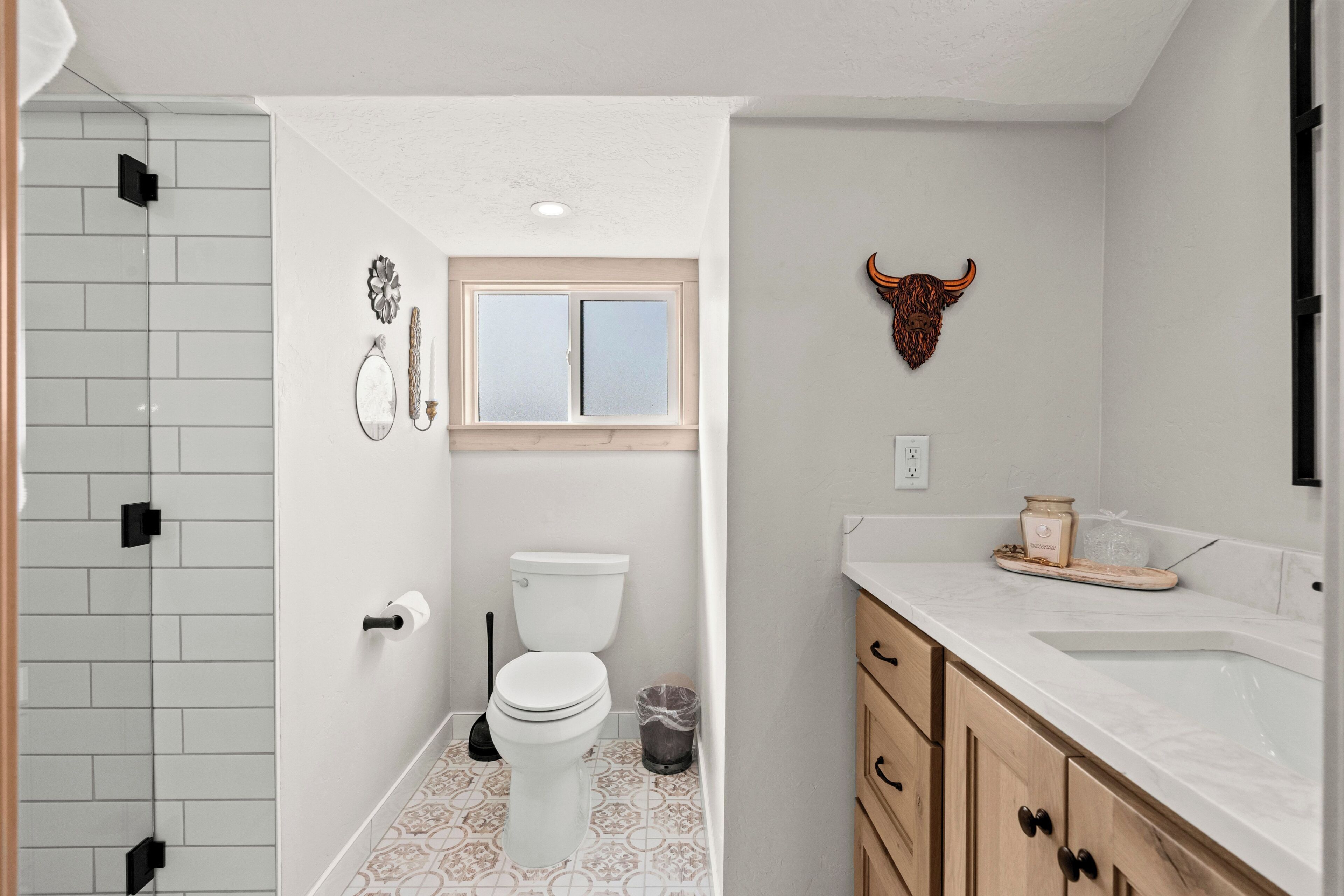 A bathroom with a toilet, a sink, and a shower area.