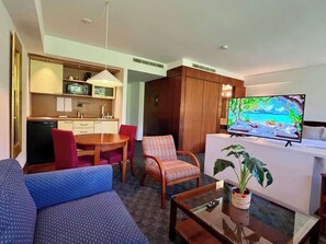 Ein Hotelzimmer mit Wohnbereich, einer Küchenzeile und einem Fernseher, der einen schönen Ausblick zeigt.