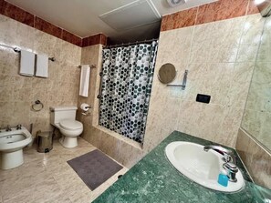 Ein Badezimmer mit Toilette, Bidet, Waschbecken und Dusche.