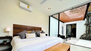 A modern bedroom with a large bed, a wooden bench, a nightstand, and a ceiling fan. - Álamo House in Downtown Mérida, Pool, 2 BR (Merida)