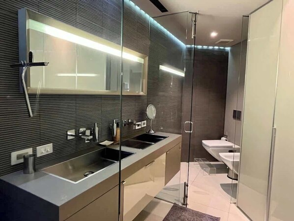 A modern bathroom with a glass shower enclosure, a double sink vanity, and a separate toilet area. - Lux+comfort at Campo Alegre|Design & connectivity (Caracas)