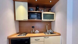 A compact kitchen with a microwave, toaster, sink, and a dishwasher. - Tu escape en caracas, apartamento moderno (Caracas)