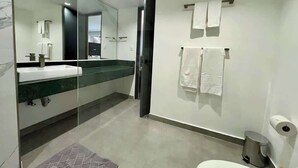 A modern bathroom with a glass shower enclosure, a white sink, and a toilet. - Disfruta de esta acogedora habitación en Caracas (Caracas)