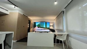 A modern hotel room with a flat-screen TV, a desk, and a chair. - Disfruta de esta acogedora habitación en Caracas (Caracas)