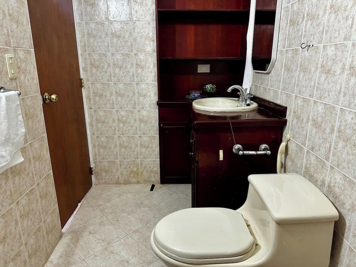 Une petite salle de bain avec des toilettes, un lavabo et un meuble de rangement.