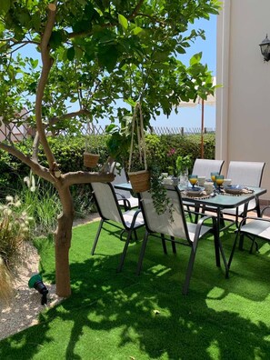 An outdoor dining area with a table set for four, surrounded by chairs, under a tree. - Hillside Cabana Maisonette in Koskinou Rhodes (Kallithea)