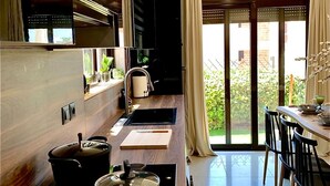 Une cuisine moderne avec un plan de travail en bois, une cuisinière et un coin repas comprenant des chaises et une table.